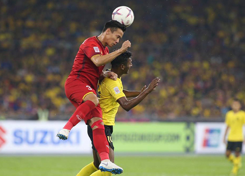 Quế&nbsp;Ngọc Hải truy cản tiền đạo Malaysia trong trận hòa 2-2 tại Bukit Jalil ngày 11/12. Ảnh: Lâm Thỏa