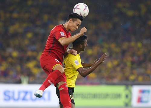 Quế Ngọc Hải trong một pha tranh bóng với cầu thủ Malaysia ở trận chung kết lượt đi. Ảnh: Đức Đồng